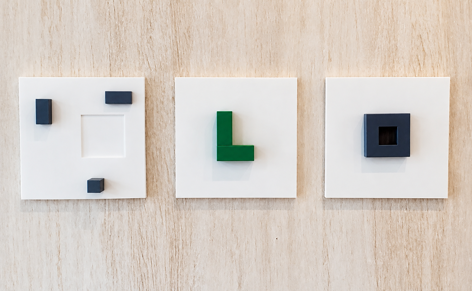 Mind Terrain (2026), frontal installation view of three white panels with geometric forms in green and navy